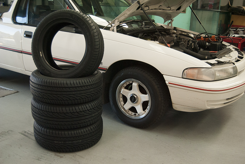 Tyres stacked in front of car